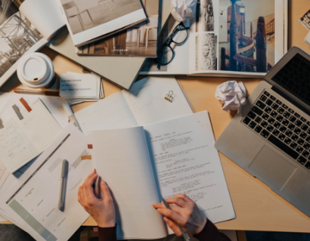 Research paper, laptop, and magazines on a table