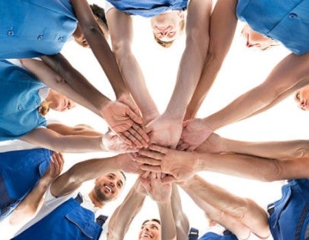 custodians huddled stacking hands 