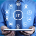 Vector image of man holding an I-Pad with I.T. components 