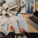 Research paper, laptop, and magazines on a table